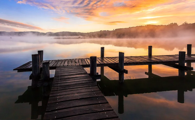 Holzsteg am see bei sonnenaufgang