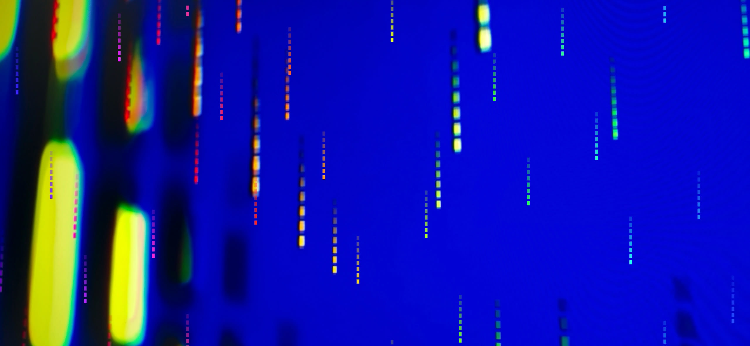 Helle Lichtspuren und gelbe Formen vor tiefblauem Hintergrund.