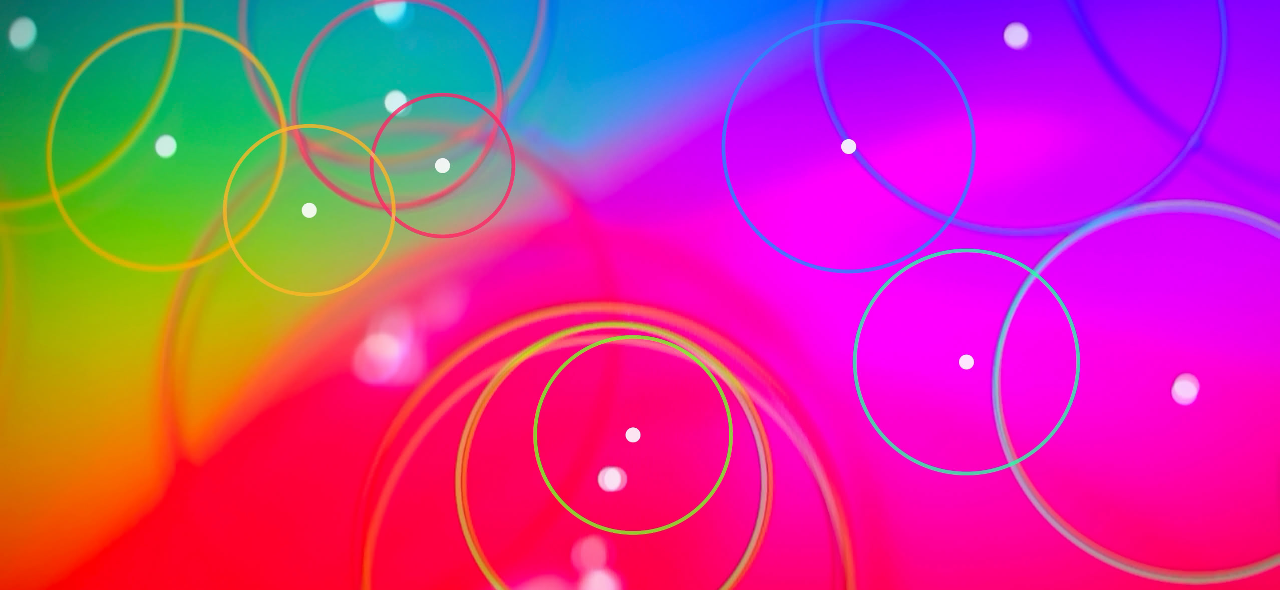 Leuchtende Kreise über fliessenden Flächen in Pink, Gelb, Grün und Blau.
